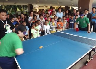 The crowd watches in awe as two students play a game of blindfolded table tennis.